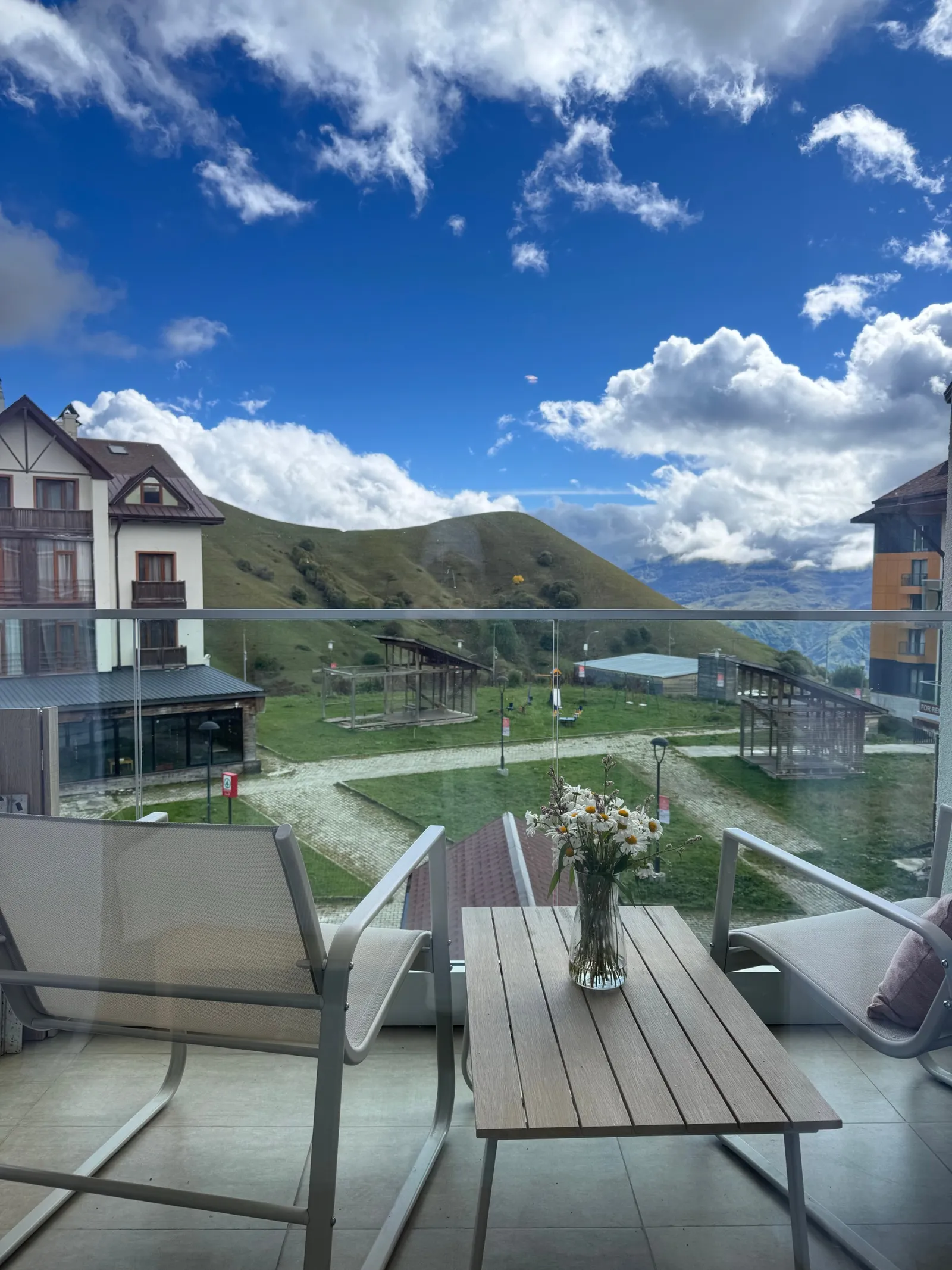 The view from the balcony: the green slopes above the resort, with the lift lines below